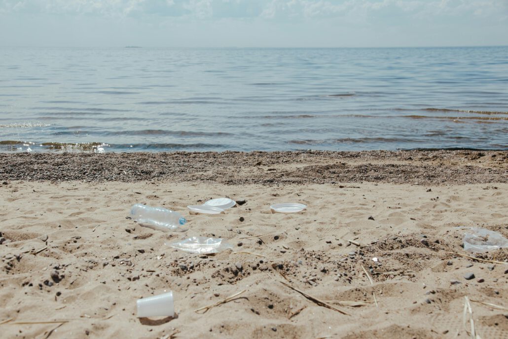 pexels-photo-9034664-9034664 Image depicting plastic pollution and litter scattered along a sandy beach shore.