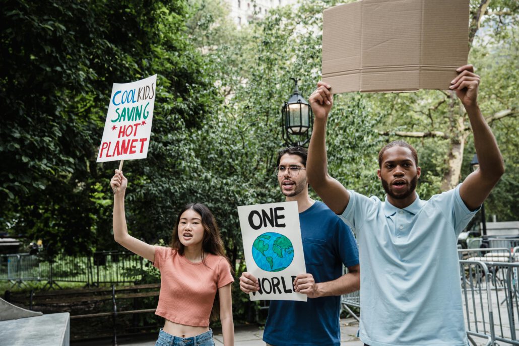 Diverse group of young activists holding signs at a climate protest outdoors.